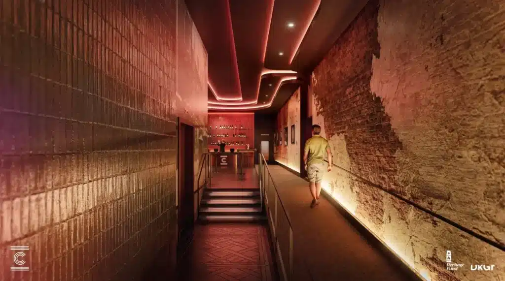 Rendering of the new eastern lobby at the Crump Theatre, with an exposed historic brick wall, large windows, and a modern bar area.