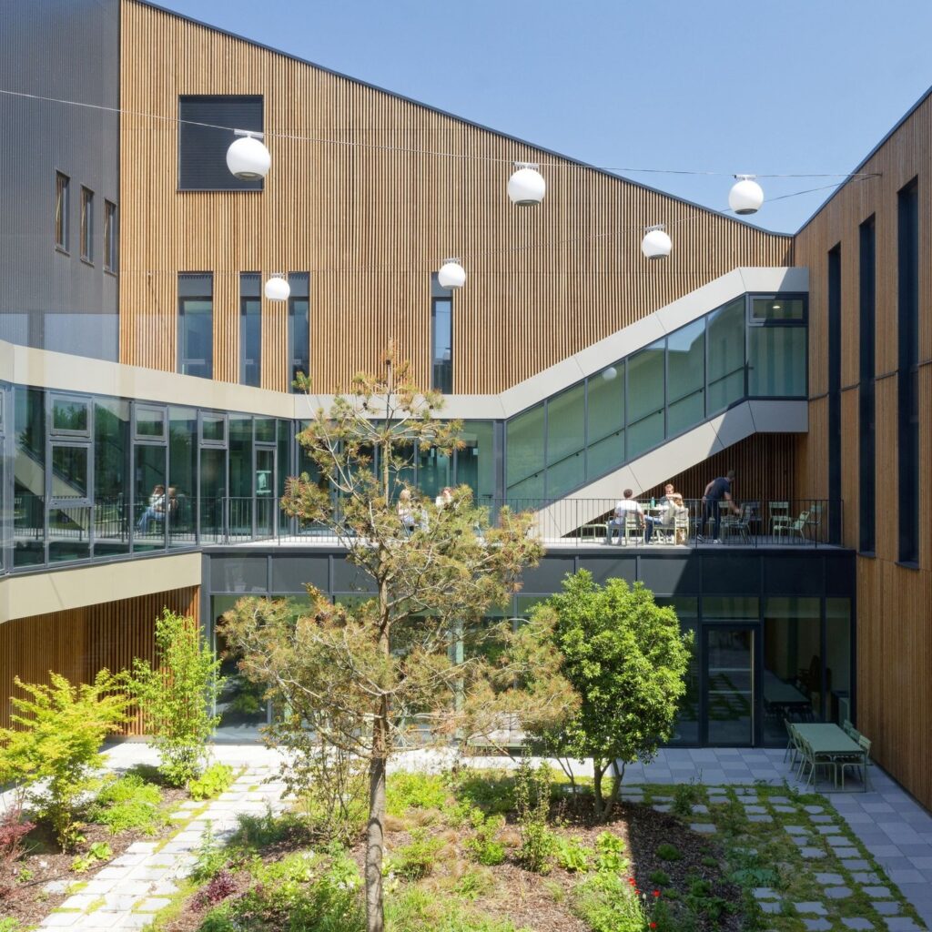 منطقة الاستقبال في مبنى إيكوسيستيم دي، تتميز بمكتب خشبي وألواح جدارية خشبية، مما يوضح استخدام مواد البناء الطبيعية.