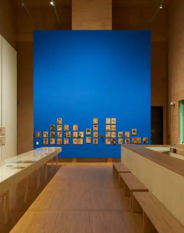 Exhibition space inside the foundation featuring a blue display wall and wooden interior finishes