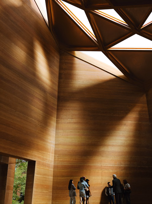 
Interior timber walls and geometric skylight inside cultural pavilion
