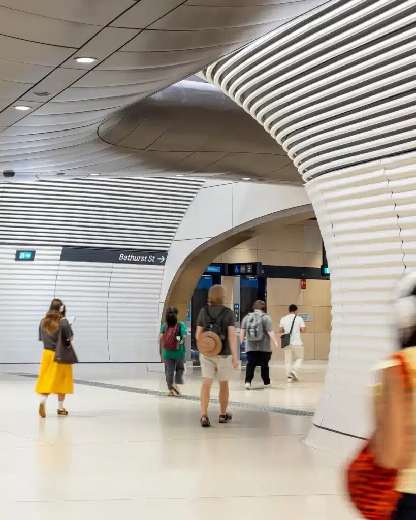 Gadigal Metro Station underground platform with sculptural ceiling volume and custom aluminum tube-lined walls creating symmetrical visual depth