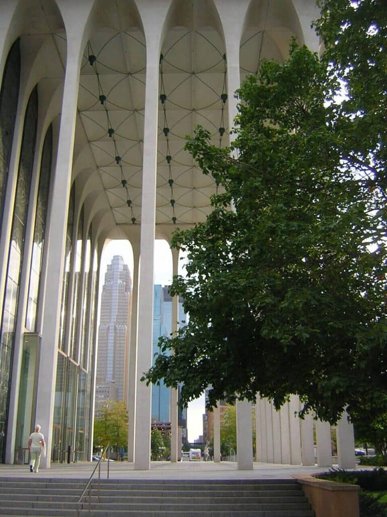 Lincoln Center theater building with reflecting pool and monumental white arches in New York City.