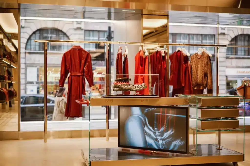 Industrial interior of the Ferrari flagship store featuring stainless steel ceiling panels and red accessories.