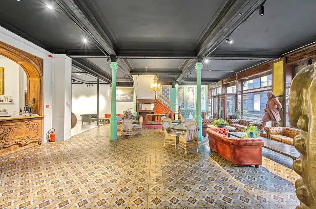 
منطقة جلوس كلاسيكية في مصنع بروكسل مع أرائك جلدية ودرج خشبي وألواح سيراميك مزخرفة