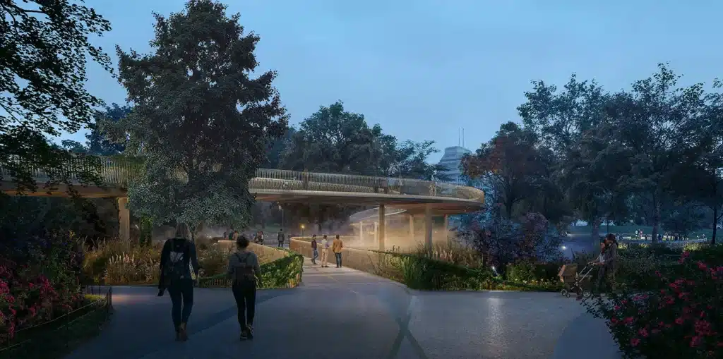 A dusk rendering of the proposed QEII memorial walkway, its modern, illuminated form contrasting with the natural park setting.