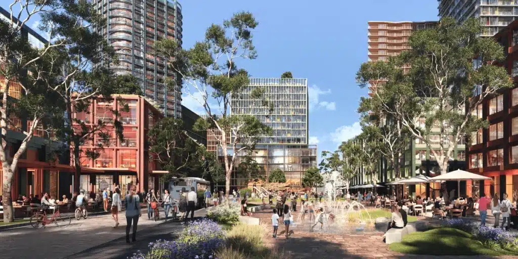 A rendering of a large park space in the Sydney Olympic Park 2050 plan, with children playing on a green lawn surrounded by high-rise residential towers.