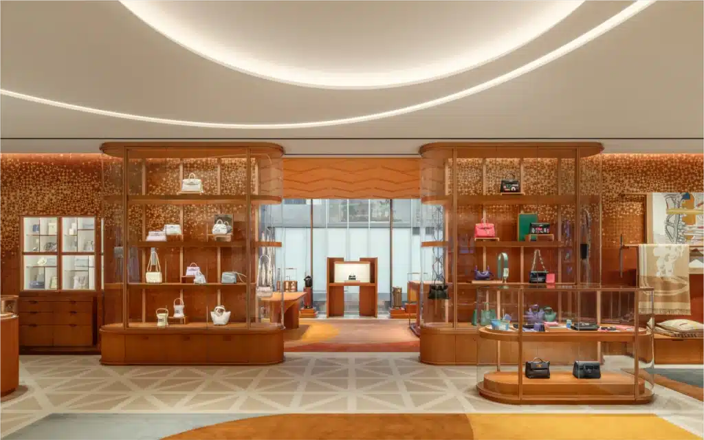 
التصميم الداخلي لمتجر هيرميس بكين الرئيسي، يظهر خزائن العرض مع حقائب اليد والأرضيات ذات النقوش الهندسية.