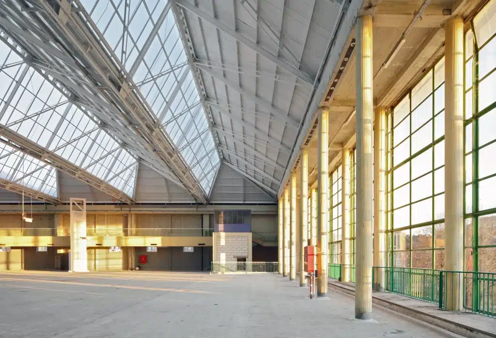 Large exhibition hall with sawtooth roof sheds and glass facade inside Charleroi Palais des Expositions