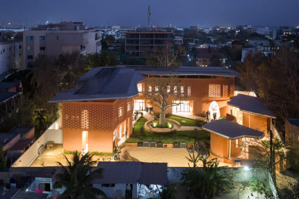 Aerial night view of Goethe-Institut Dakar showing full site layout and solar panels