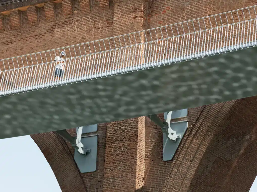 Wide panoramic view of Albi city showing a historic stone bridge in the foreground and the new steel footbridge in the distance.