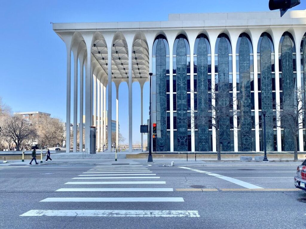Exterior corner view of the New York State Theater showing its elevated colonnade and surrounding plaza.