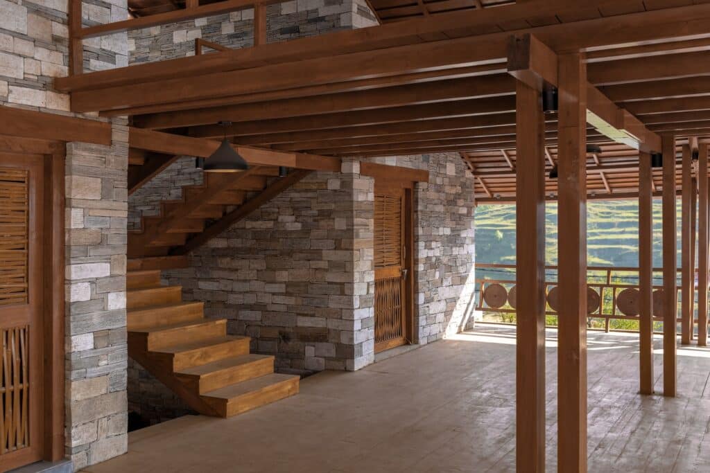 Wooden stairs leading to an upper level, showing the transition between stone walls and the open wooden deck.