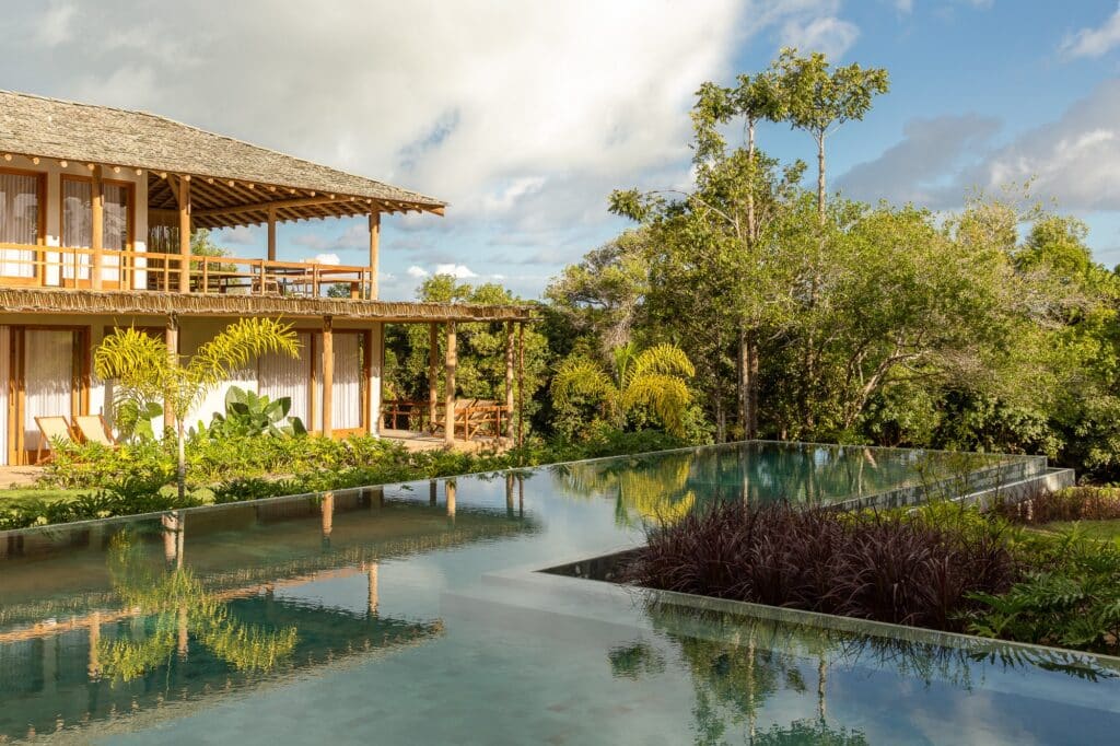 High-angle view of the infinity pool and the upper-level balcony of MP House overlooking the communal green area.