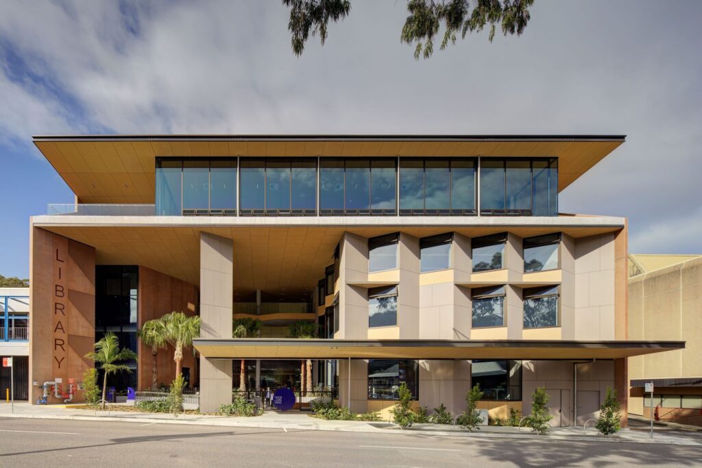 Exterior view of the Gosford Regional Library building showing the cantilevered roof, glass facade, and the public entrance at Kibble Park.