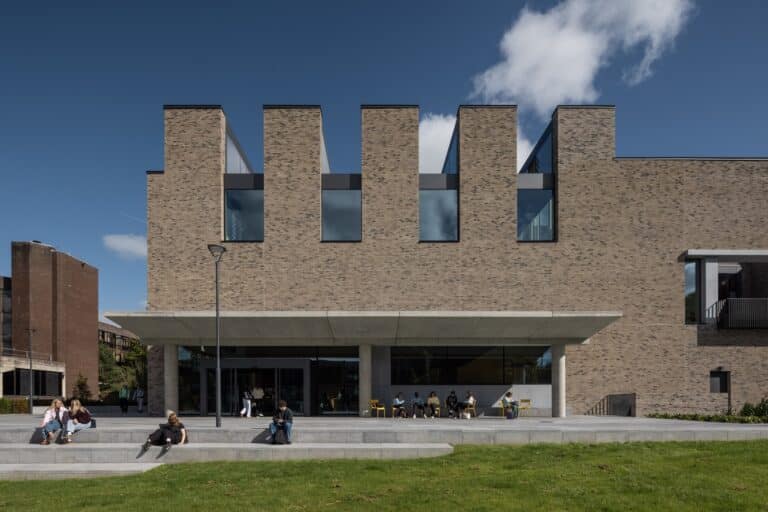Modern brick exterior of the University of Limerick New Student Centre featuring a concrete canopy and student social spaces.