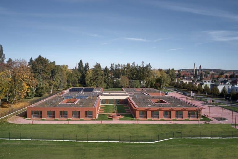 Aerial wide shot of the Senior Citizens Home in Novy Bydzov showing the four interconnected residential units and central courtyards.