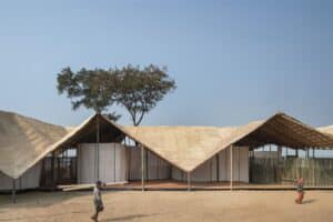 Side view of the German Pavilion at Kerala Literature Festival showing the bamboo structural layers and calico fabric curtains on the Kozhikode beach.