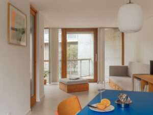 A hallway view in the Trommel project showing a translucent sliding door and a glimpse into the bathroom and study area.