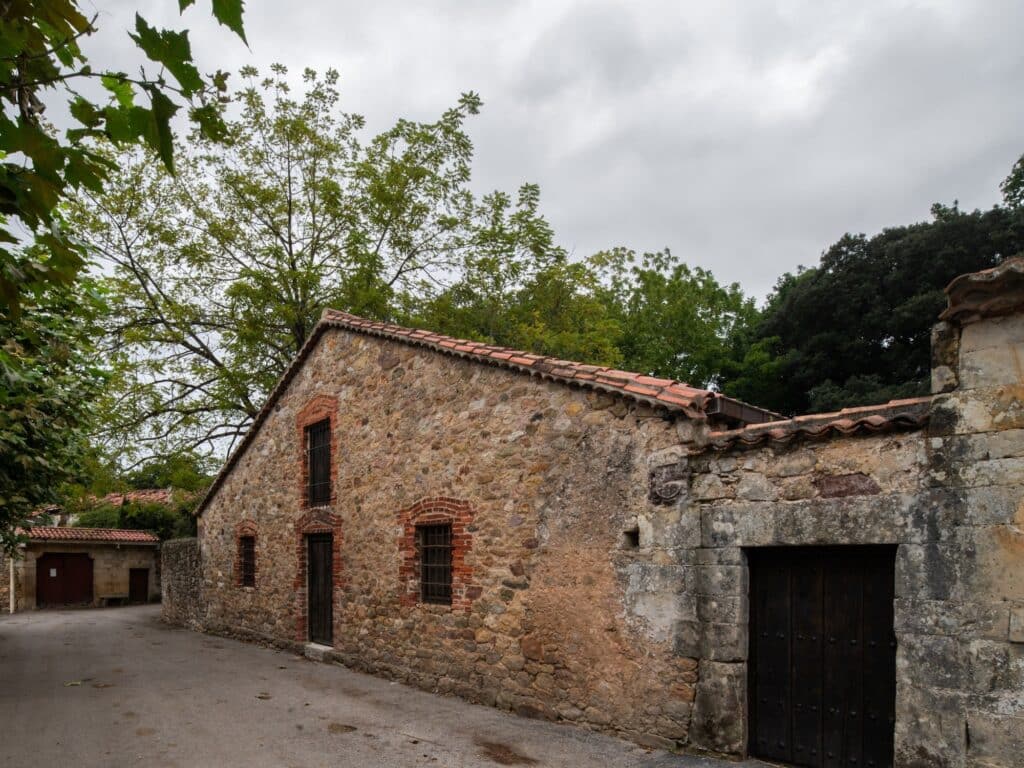 Exterior view of the Tiled Sky Pavilion's stone facade with traditional brick-lined windows in a rural alley.