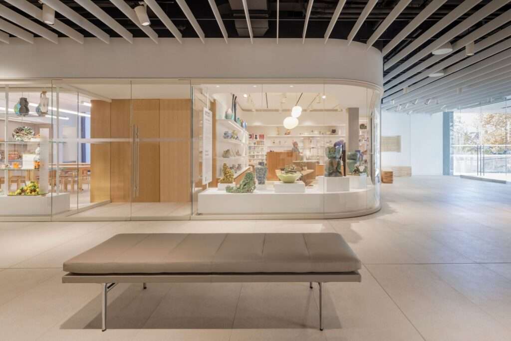 Modern interior of the Gardiner Museum ground floor with a curved glass partition and ceramic displays.