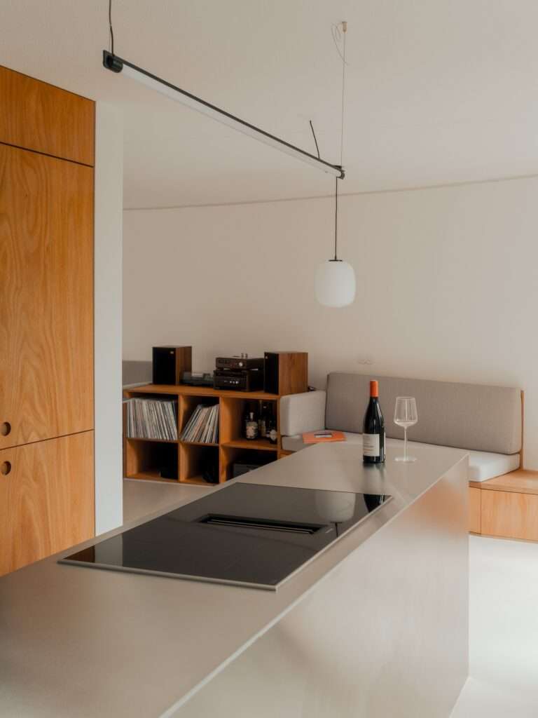 Built-in wooden desk and bookshelves next to a large window in the Trommel apartment.