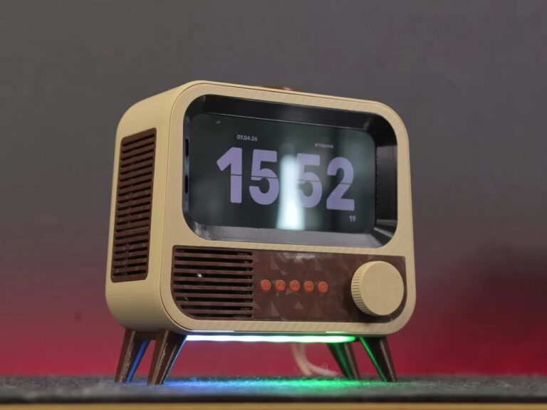 Front view of the retro-style smart speaker displaying a large digital clock (15:52) with an illuminated green base.