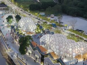 Aerial evening view of Yongping Warehouse renovation in Foshan showing glowing hexagonal dome structures on the rooftop park by Huadi River.