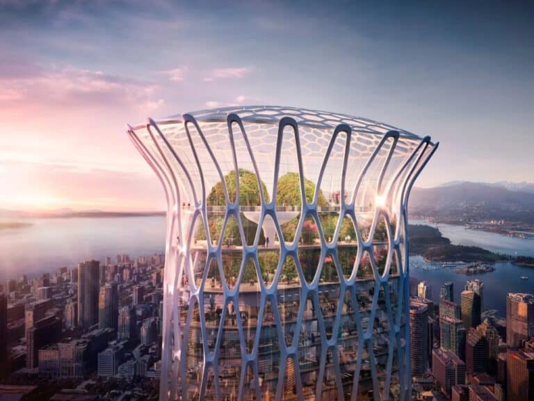 A close-up aerial view of the biomorphic crown of 595 West Georgia Street skyscraper at sunset, showing the white exoskeleton structure, glass facade, and a multi-story indoor public sky garden with trees and visitors.