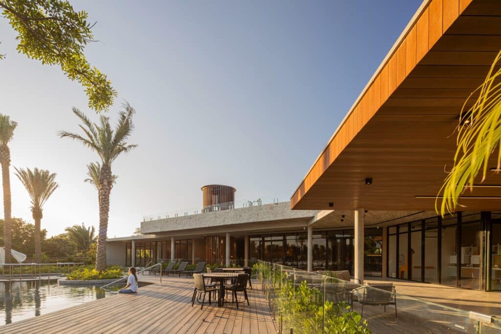 Sunny outdoor deck of the leisure area with wooden flooring, seating arrangements, and the lake view in the background.