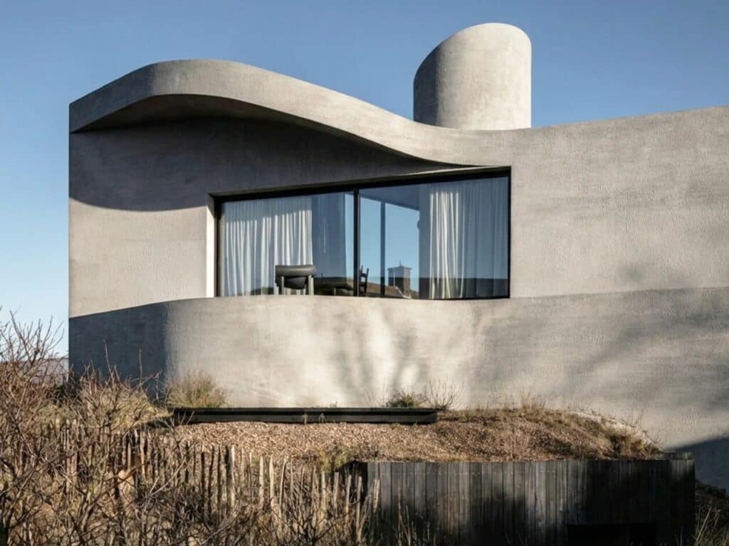 Side view of Villa Nouvelle Vague showing the curved concrete roofline mimicking tide recession marks on sand.