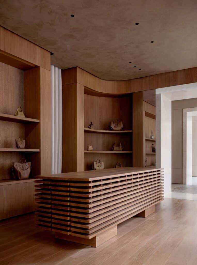 Interior of the Wood Room featuring oak shelving, a slatted wooden counter, and curved architectural lines.