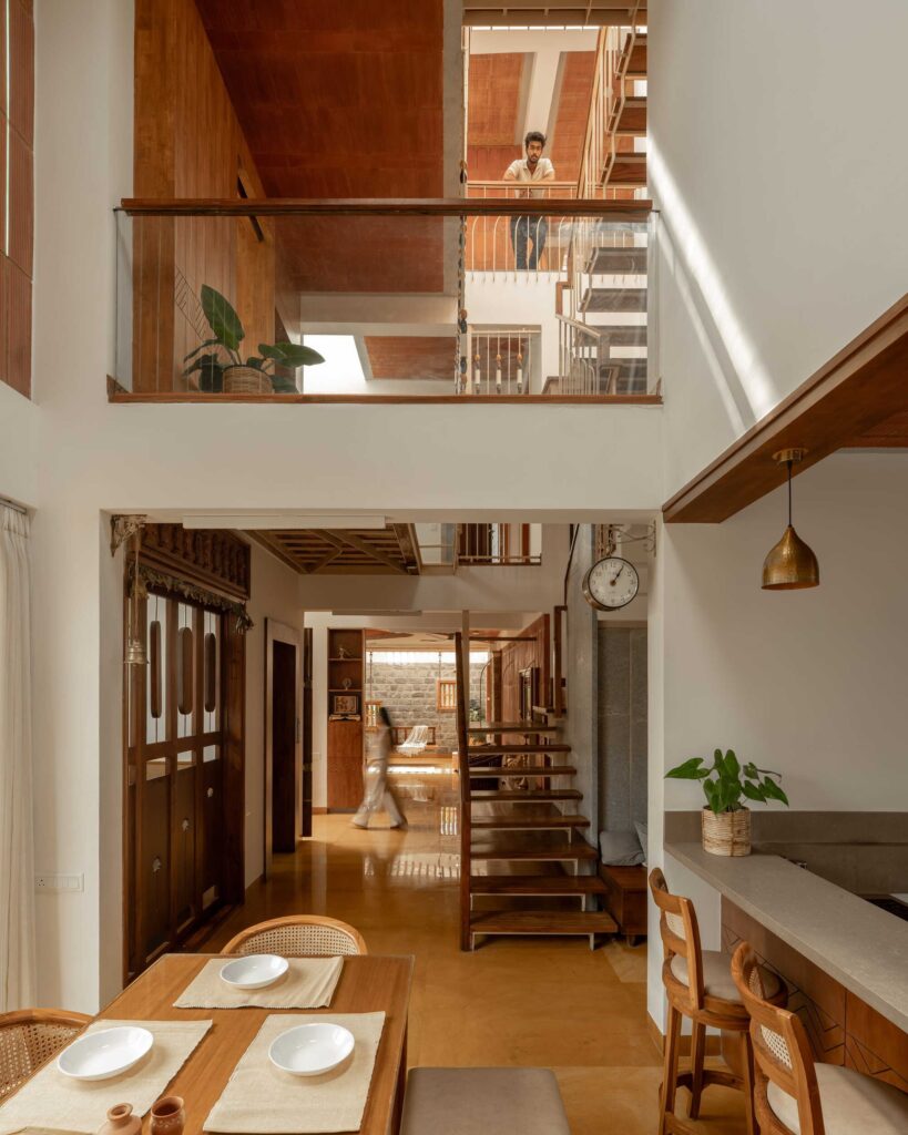 Double-height living area in Thallero House showing the connection between the ground floor and the first-floor balcony.