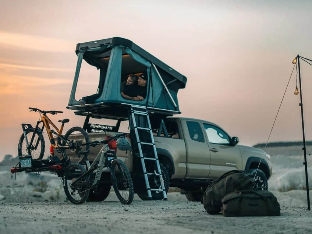 Night view of a Thule Widesky tent on a pickup truck with interior lighting turned on.