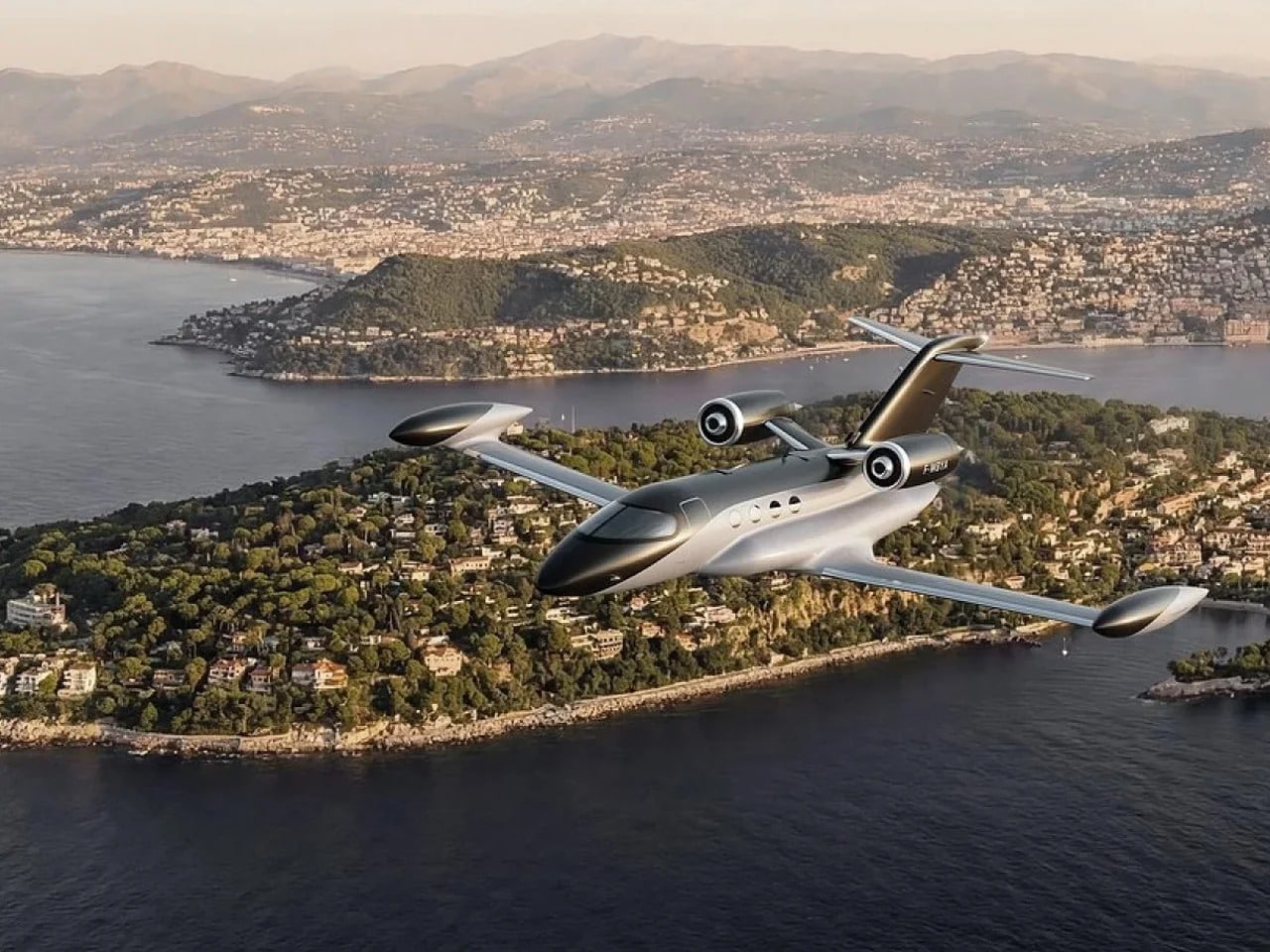 Side view of the BYA-I One hydrogen-electric jet flying over a coastal city and mountains, showcasing its sleek aerodynamic fuselage and rear-mounted propfan engines.