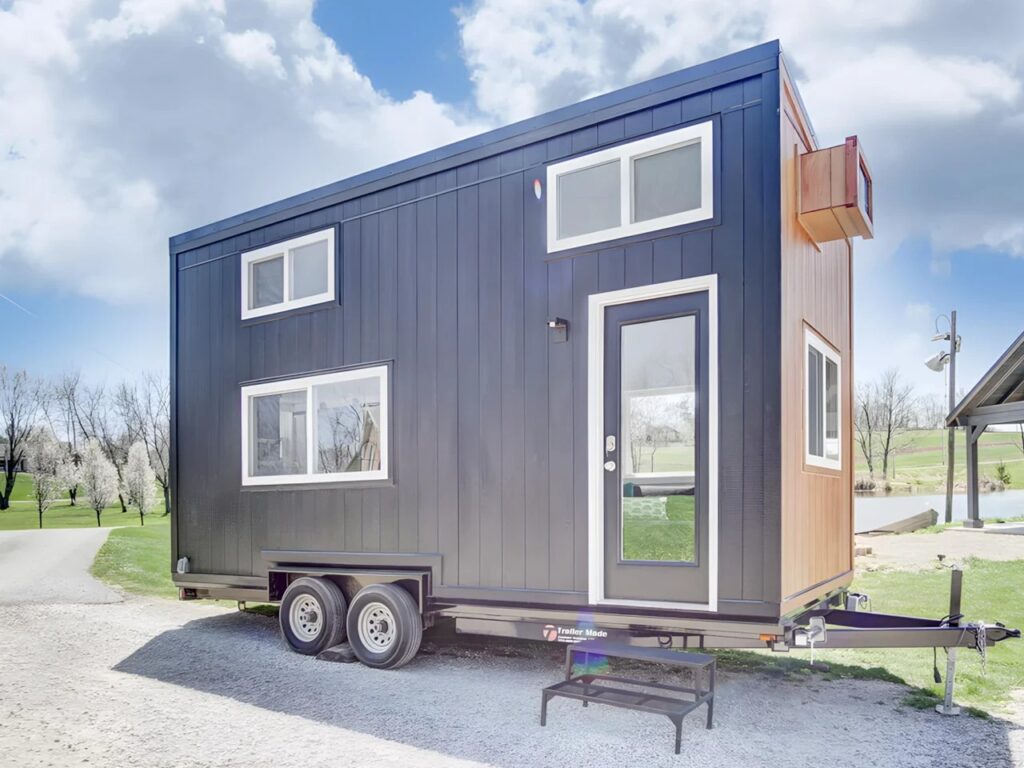 Perspective view of the Espresso tiny house exterior showing the combination of black siding and warm wood accents.