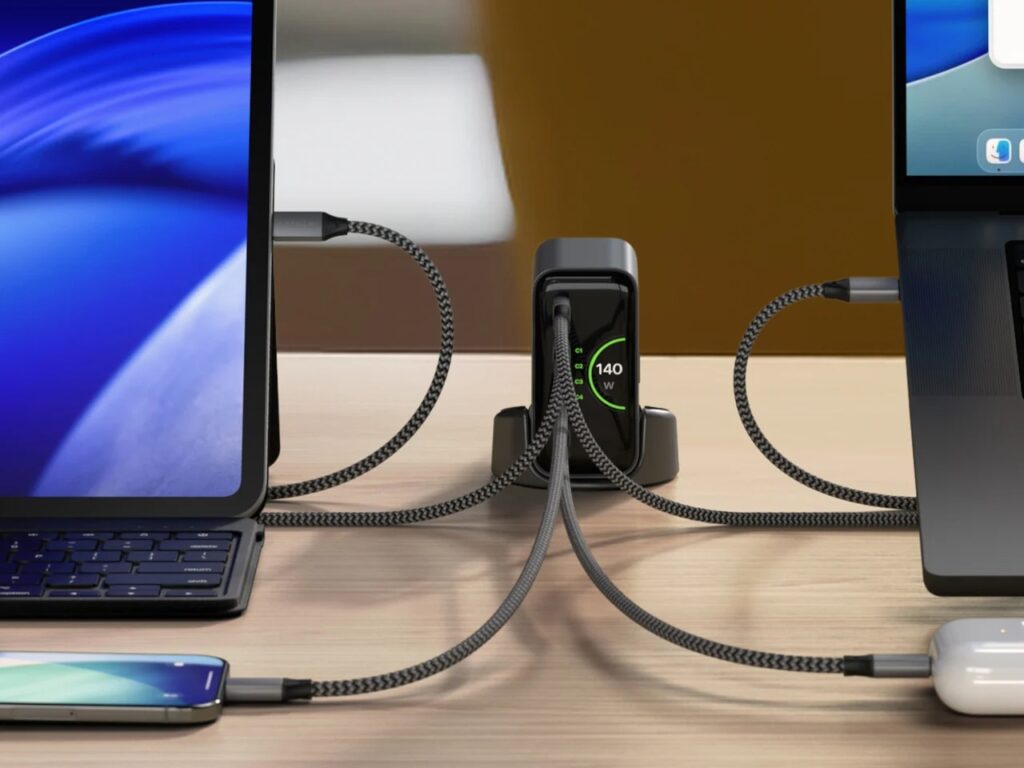 Front view of Satechi ChargeView 140W charger in vertical stand mode, connected to four devices including an iPad and MacBook Pro.