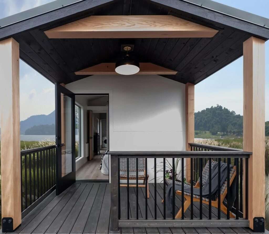 Covered wooden deck of the Urban Gable Park model overlooking a scenic landscape with mountains.