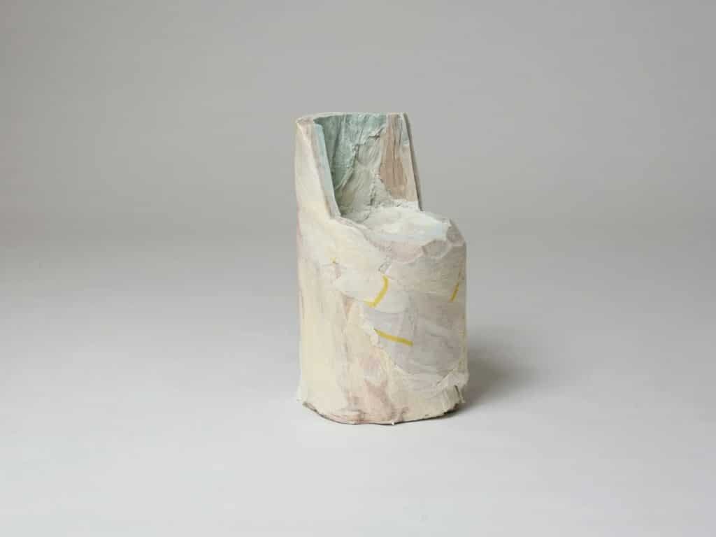 A minimalist side chair sculpted from a single solid cylinder of compressed recycled paper.