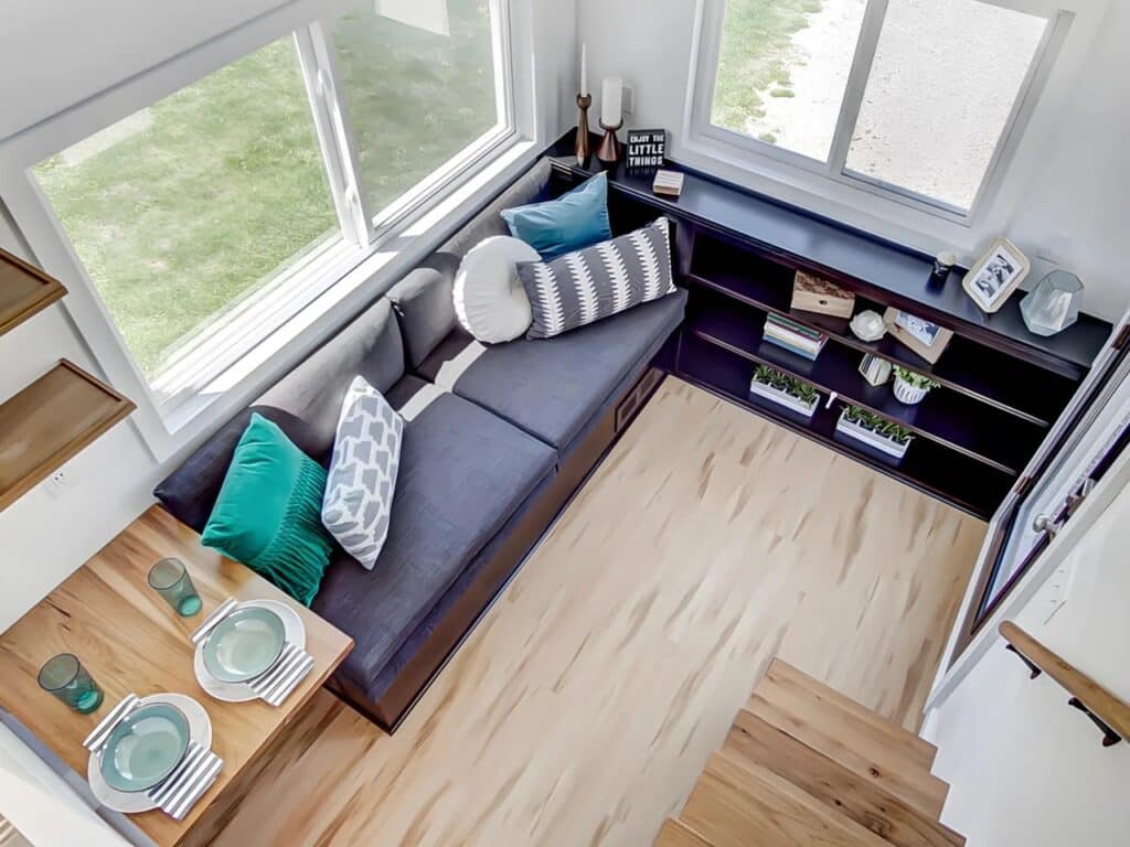 Overhead interior view of the Espresso tiny house living area with a built-in sofa and storage shelves.