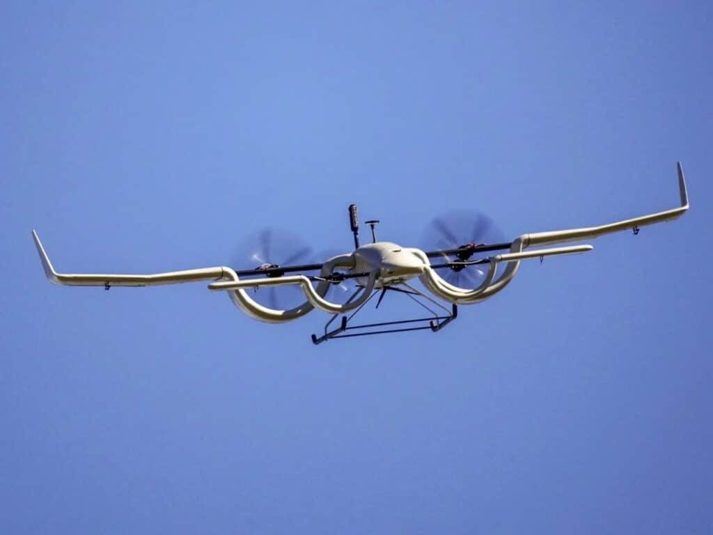 HopFlyt Cyclone aircraft in mid-flight against a clear blue sky, demonstrating the rotation of its channel wing propulsion.
