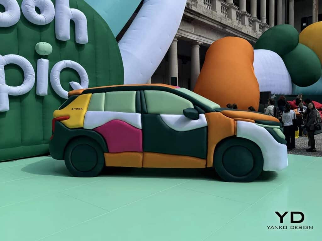 Full side profile of the Skoda Epiq electric car with inflatable panels in pink, green, and orange.