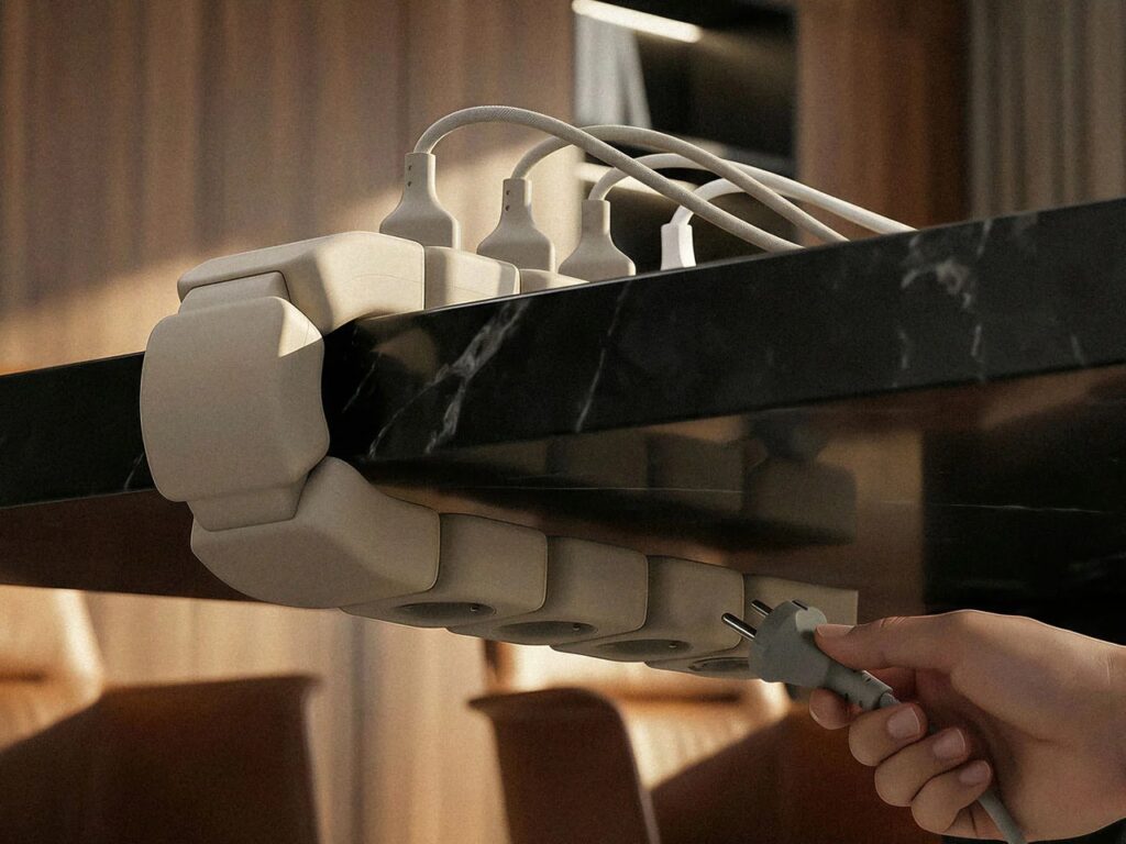 Edge power unit clamped to a thick marble desk edge with cables plugged into top and bottom ports.
