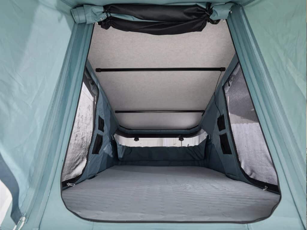 Empty interior of the Thule Widesky tent showing the quilted mattress and large mesh windows for ventilation.