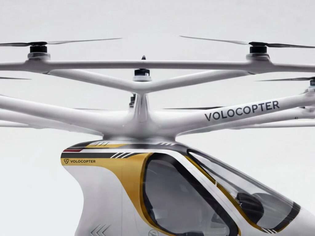 A high-angle detail shot of the central pylon structure and surrounding white rotor arms of the Volocopter VoloXPro overhead ring.
