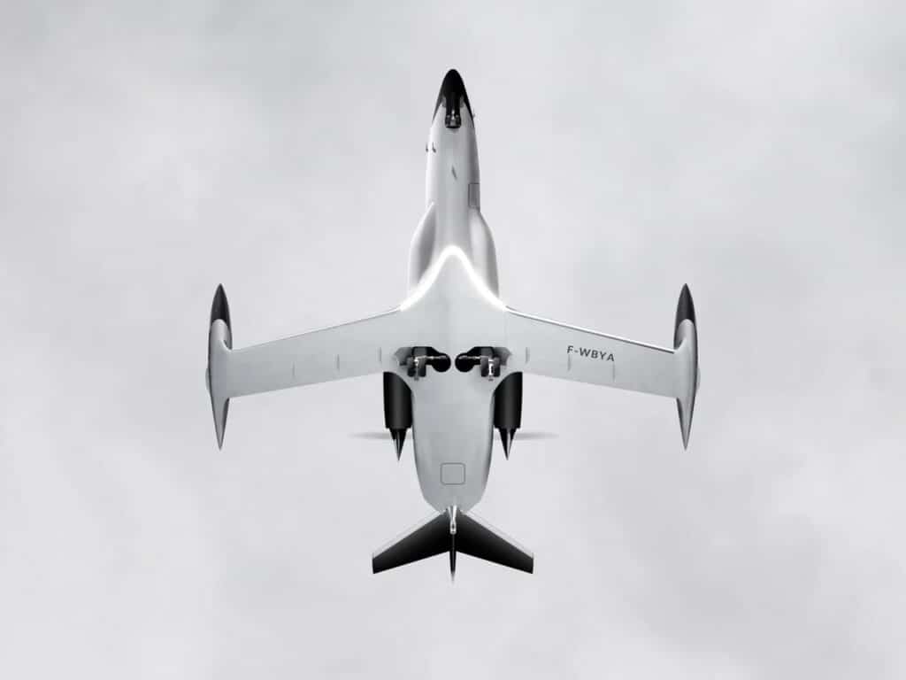 Underside view of the BYA-I One hydrogen-electric aircraft in flight against a cloudy sky, showing the landing gear and wing structure.