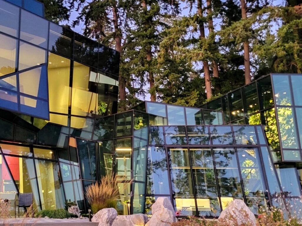 Night view of F-House showing glowing interior lights through different levels of glass transparency and opacity.