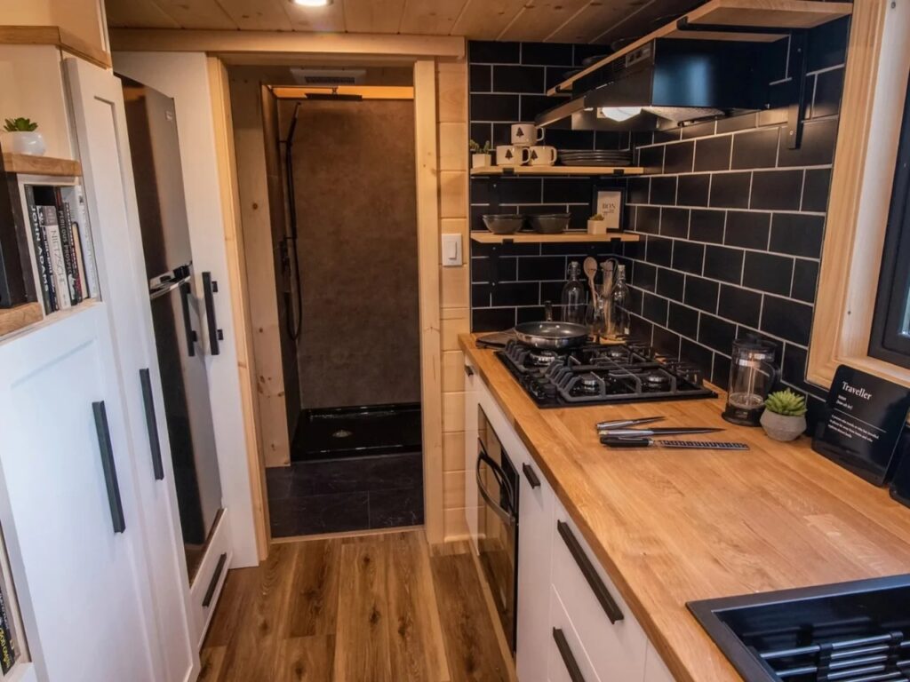 View from the kitchen toward the bathroom and shower area in the Scandi Inn tiny home.