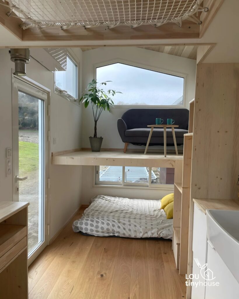 Interior view of V&eacute;ronique tiny house showing the inverted layout with an upper-level living area.