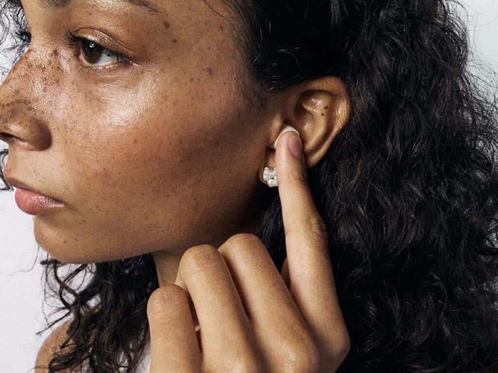 Side profile of a woman using GOB eco-friendly earplugs, highlighting the ergonomic fit and natural aesthetic.