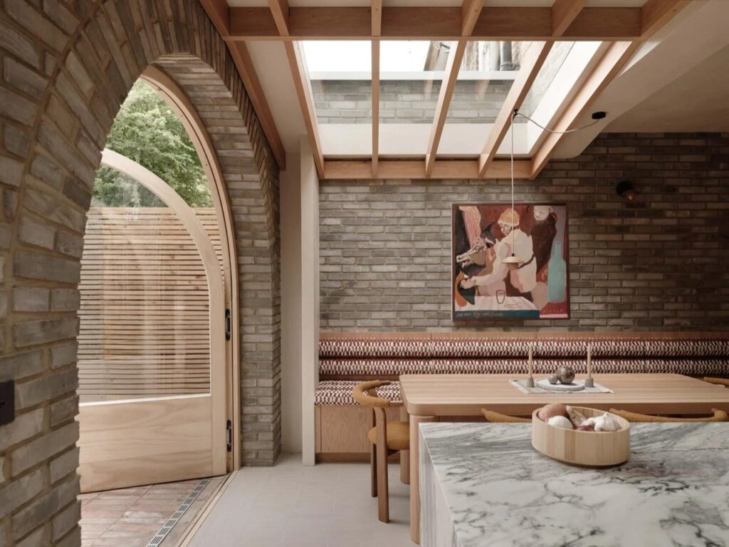 Dining nook with exposed brick walls, a skylight, and Douglas Fir ceiling beams.